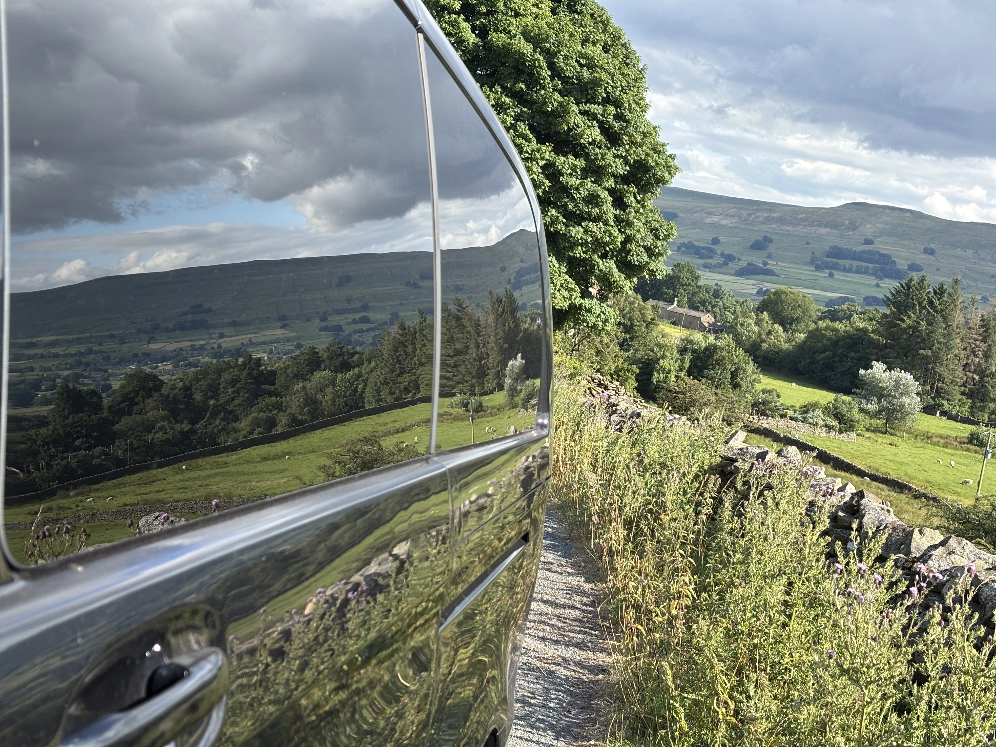 A black Mercedes-Benz V-Class amid the Yorkshire Dales on a bright summer day